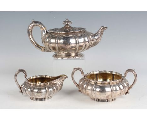 A William IV and later silver three-piece tea set of squat circular lobed form, crest engraved, comprising teapot, two-handle