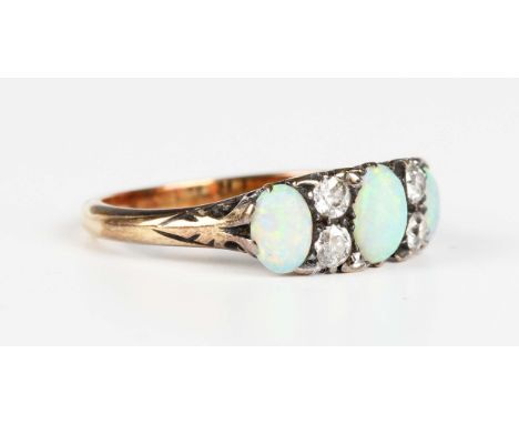 A gold, opal and diamond ring, mounted with three graduated oval opals alternating with two pairs of cushion cut diamonds, un