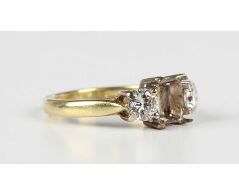 An 18ct gold ring, claw set with two circular cut diamonds, weight 3.5g, ring size approx I1/2 (the central rectangular cut d