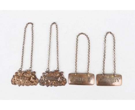 A pair of William IV silver decanter labels, each embossed with two putti amongst bunches of grapes, one inscribed 'Madeira',