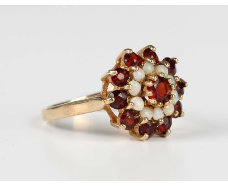 A 9ct gold, garnet and opal cluster ring, claw set with the principal circular cut garnet at the centre, Birmingham 1975, wei