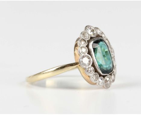 A gold, diamond and green tourmaline cluster ring, mounted with the cushion cut green tourmaline within an openwork surround,