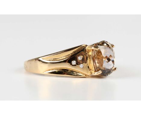 An 18ct gold ring, claw set with the oval cut yellow tanzanite between diamond three stone shoulders, weight 6.3g, ring size 