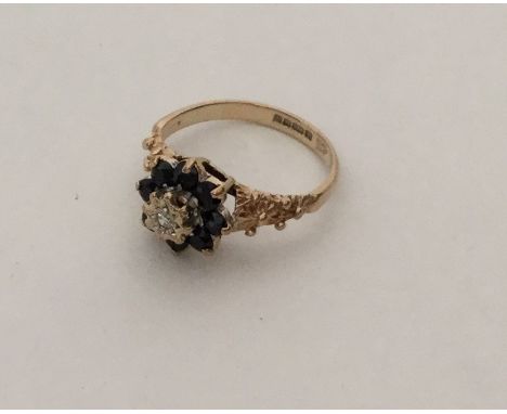 A sapphire and diamond modern cluster ring in 9 carat. Approx. 2 grams. Est. £55 - £65.