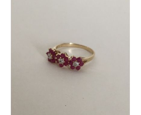 A ruby and diamond triple cluster ring in 9 carat mount. Approx. 2.3 grams. Est. £45 - £55.