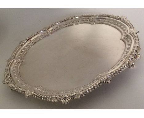 A good quality Edwardian silver salver attractively decorated with leaves and bead work rim on ball and claw feet. Approx. 69