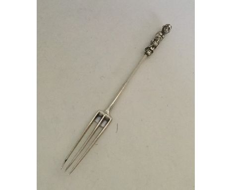 A rare 18th Century cast silver three prong fork with figure terminal. Approx. 33 grams. Est. £100 - £150.