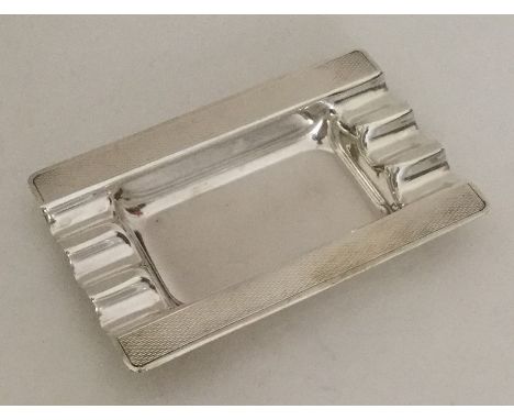 A silver Art Deco ashtray with engine turned decoration. Approx. 45 grams. Est. £20 - £30.