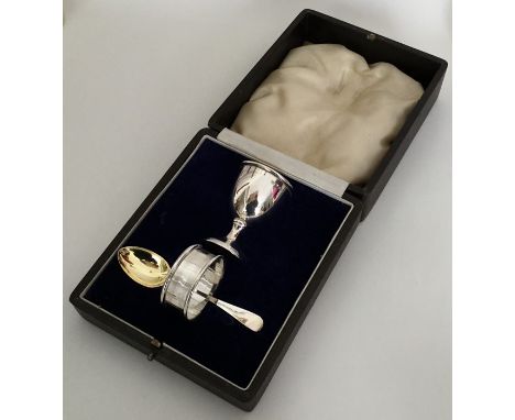 A cased silver egg cup, napkin ring and spoon. Approx. 42 grams. Est. £40 - £50.