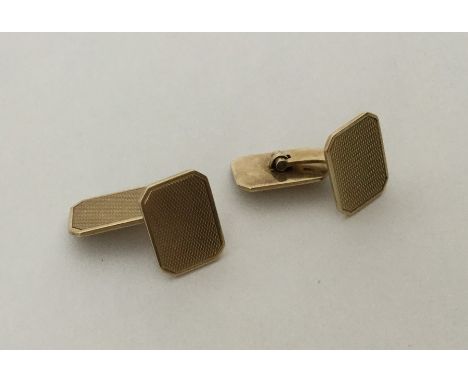 A pair of 14 carat gold engine turned cufflinks. Approx. 11.4 grams. Est. £200 - £300.