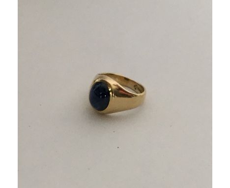 A heavy gent's 18 carat cabochon sapphire gypsy set ring in rubover mount. Approx. 8 grams. Est. £250 - £300.