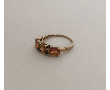 A 9 carat three stone ring mounted with diamond points. Approx. 2 grams. Est. £70 - £80.