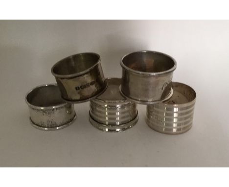 A bag containing heavy silver and other engine turned napkin rings. Approx. 143 grams. Est. £60 - £80.