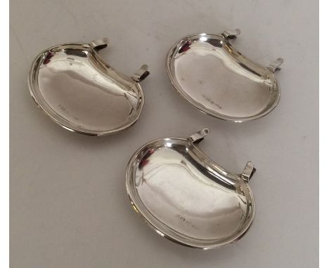 An unusual set of three silver saucer dishes with clips to sides. Birmingham. By H&amp;T. Approx. 45 grams. Est. £50 - £80.