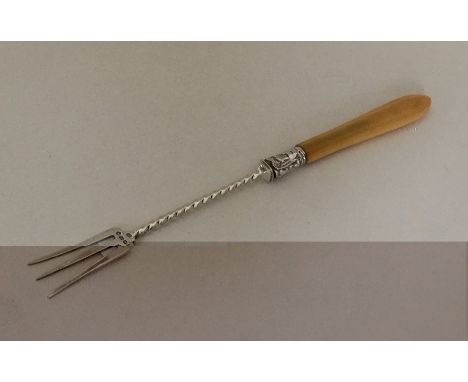 A silver and ivory mounted pickle fork with twisted decoration. Approx. 23 grams. Est. £15 - £20.