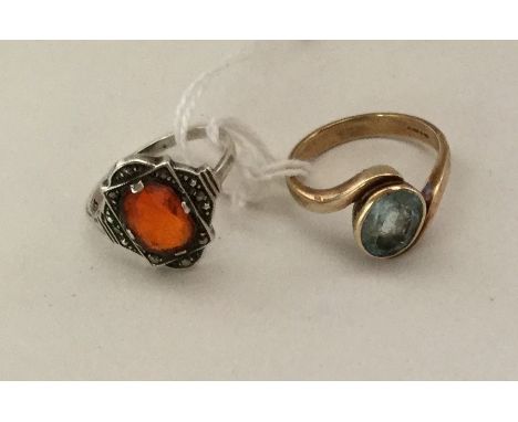 A blue stone crossover ring in 9 carat, approx. 4.1 grams; together with a silver ring, approx. 2.7 grams. Est. £30 - £40.