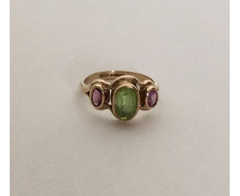 A peridot mounted three stone ring in 9 carat setting. Approx. 3.7 grams. Est. £70 - £80.