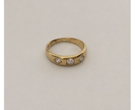 An Antique diamond three stone gypsy set ring in 18 carat gold band. Approx. 4.5 grams. Est. £150 - £200.