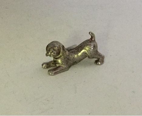 A miniature Continental silver figure of a playing dog. Approx. 31 grams. Est. £20 - £30.