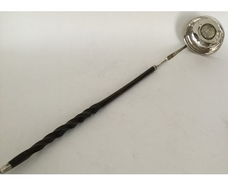 A Georgian silver toddy ladle with central coin to whalebone handle. Approx. 44 grams. Est. £35 - £45.