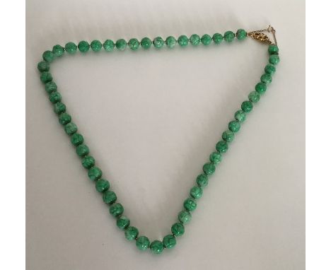 A good carved jade string of beads with high carat gold clasp. Approx. 60 grams. Est. £700 - £800.