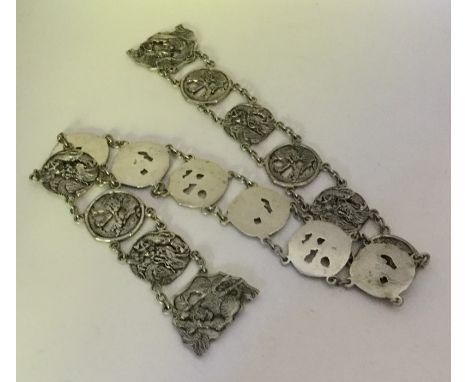 A heavy Chinese silver panelled belt decorated with animals and figures. Approx. 245 grams. Est. £250 - £300.