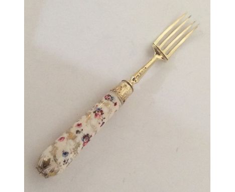 A silver gilt and porcelain mounted dessert fork. London 1883. Approx. 70 grams. Est. £20 - £30.
