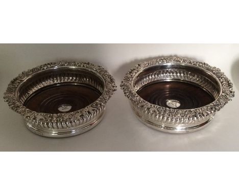 A good pair of Georgian silver wine coasters with scroll decoration. Sheffield 1822. Approx. 567 grams. Est. £400 - £500.