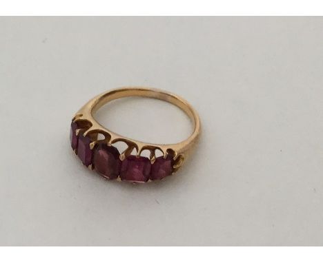 A large graduated five stone ruby ring in 18 carat claw mount. Approx. 6.2 grams. Est. £150 - £200.