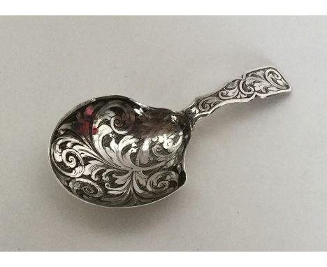 An Antique silver caddy spoon engraved with scrolls and leaves. London 1879. By CW. Approx. 10 grams. Est. £80 - £120.