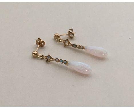 A pair of opal and gold tapering earrings with loop tops. Approx. 1.4 grams. Est. £50 - £60.