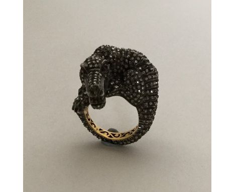 A large unusual gold ring in the form of an alligator, the pave diamond body to ruby eyes. Approx. 18.8 grams. Est. £700 - £8