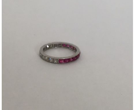 An attractive diamond and ruby eternity ring engraved with flowers and leaves. Approx. 2.2 grams. Est. £100 - £200.