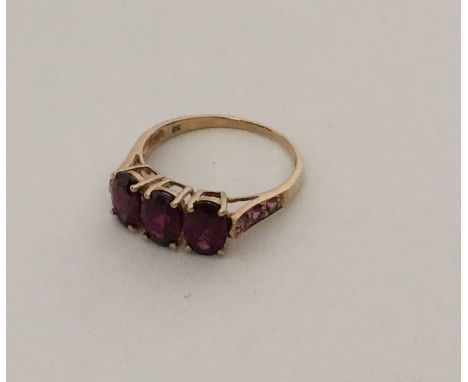 An amethyst three stone ring in 9 carat mount. Approx. 2.2 grams. Est. £55 - £65.