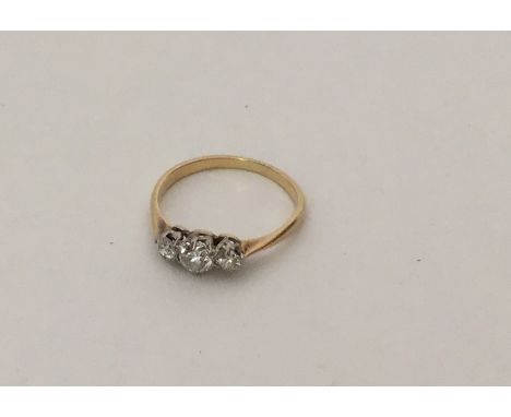 An attractive 18 carat gold and platinum three stone ring in claw mount. Approx. 1.9 grams. Est. £80 - £120.