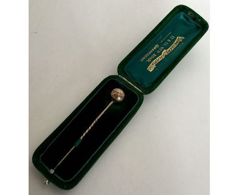 An Antique gold stick pin designed as a sphere revealing locket interior contained within original box. Approx. 5 grams. Est.