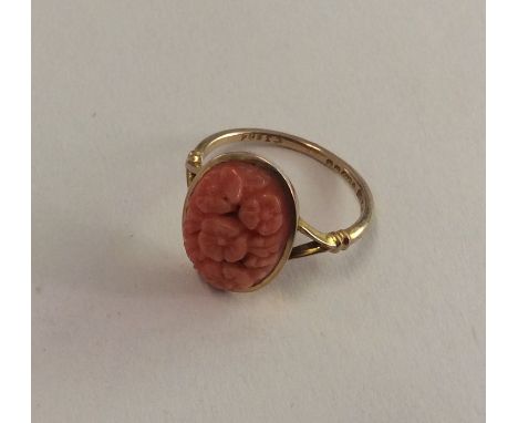 A 9 carat carved coral ring decorated with flowers. Approx. 2.4 grams. Est. £50 - £80.