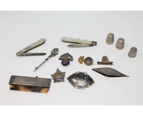 A collection of silver and white metal items including thimbles, combe, military badges, pen knives, contained in a small min