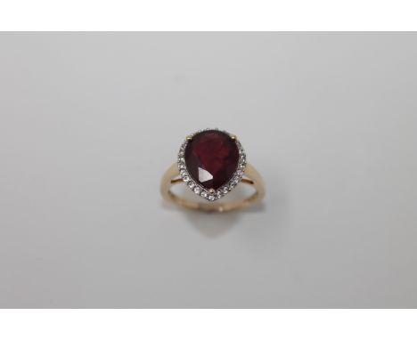 A 9ct gold heart shaped ruby ring, the central stone surrounded by a halo of diamonds, size N, 4.4g.