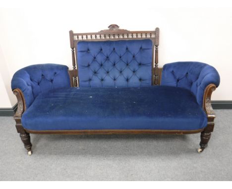 A Victorian oak button-back settee, on carved legs terminating in ceramic castors, width 186cm. 