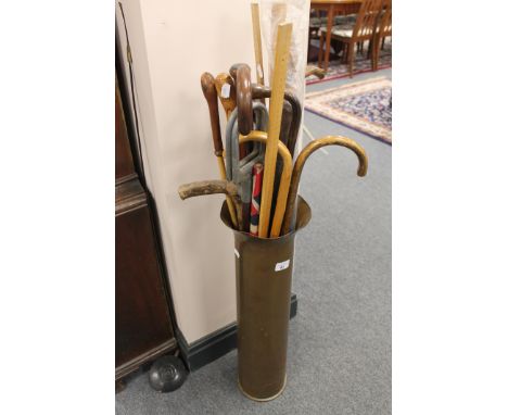 A large brass ammunition shell, together with a quantity of walking sticks, a shooting stick, canes, etc. 