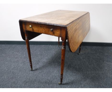 A George III mahogany dropleaf sofa table, on tapered legs terminating in brass castors, width 86cm.