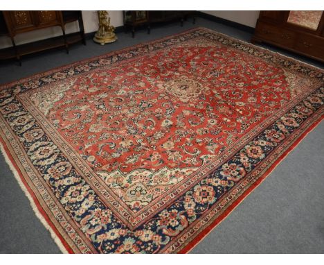 A Mahal carpet, West Iran, with a strawberry field with cusped medallion framed by spandrels and indigo borders, 413cm by 296