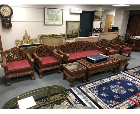 A good quality eight piece carved Eastern hardwood lounge suite, comprising of three seater settee, four single armchairs, co