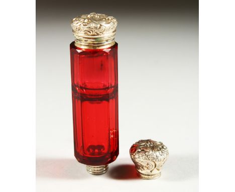 A GOOD VICTORIAN RUBY FACET CUT GLASS SCENT BOTTLE with repousse silver top. 9.5cms long.