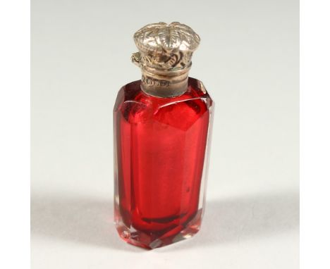 A VICTORIAN FACET CUT RUBY GLASS SCENT BOTTLE AND STOPPER with silver cap. 6cms long.