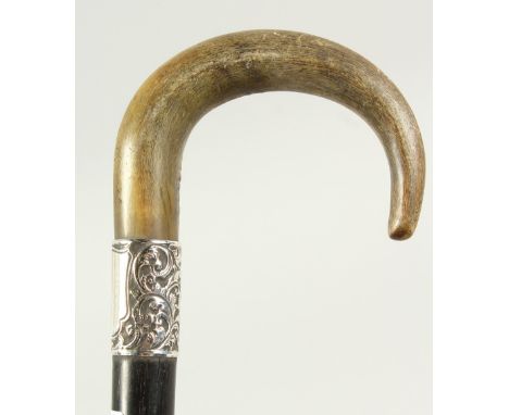 A WALKING STICK with Rhino curving handle and silver band. Circa 1900. 2ft 6ins long.