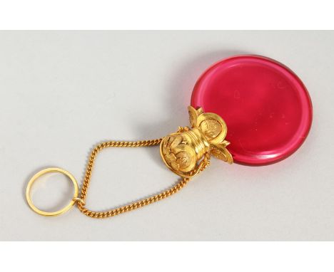 A 19TH CENTURY RUBY GLASS CIRCULAR SCENT BOTTLE with gilt cap and chain. 4.5cms diameter.