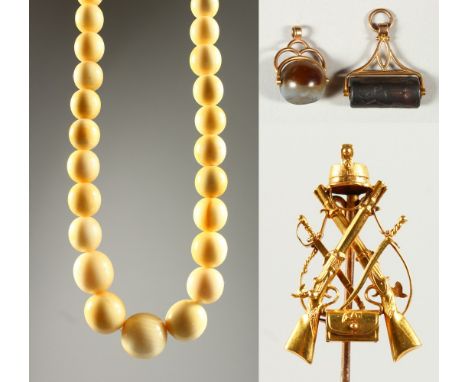 AN EARLY 20TH CENTURY IVORY BEAD NECKLACE,  a gilt metal military stick pin and two fob seals. Necklace 50cms long.