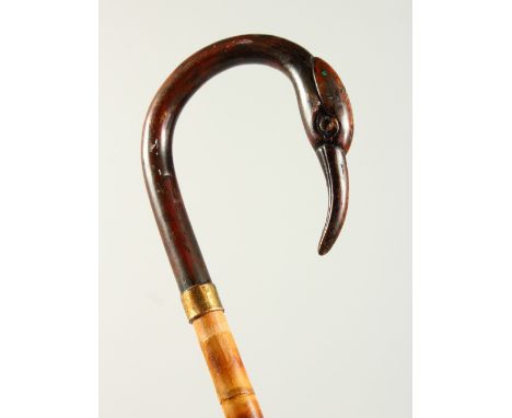 A SLENDER WALKING STICK with carved bird handle. 2ft 9ins long.